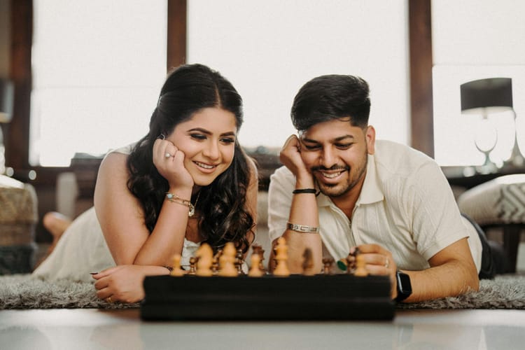 A dating couple play chess.