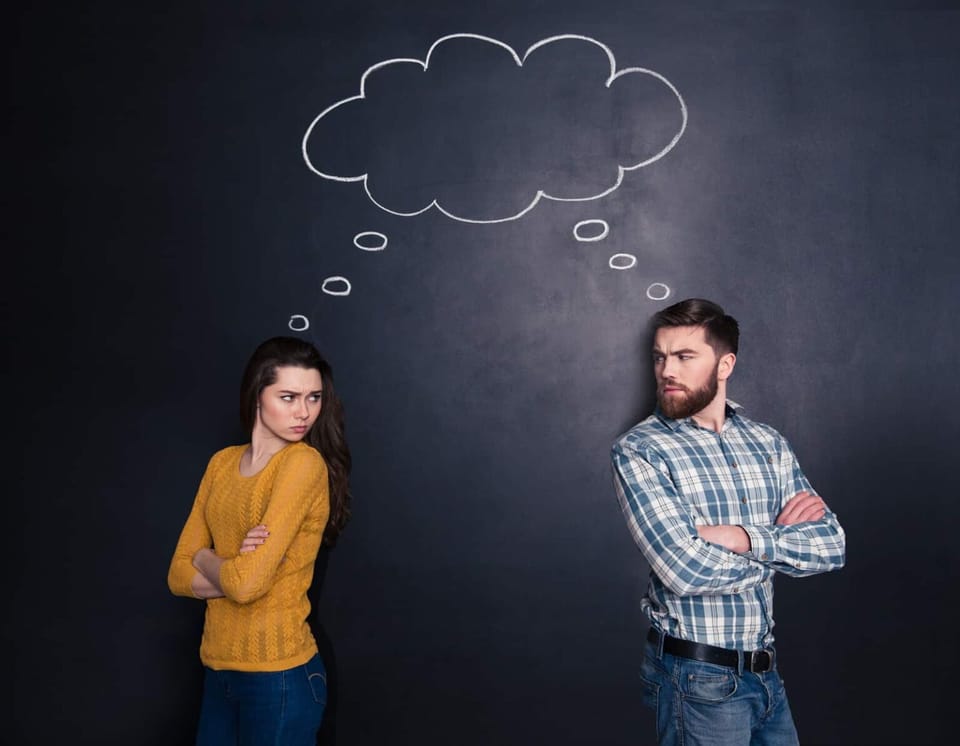 A confused couple facing away from each other but looking at each other.