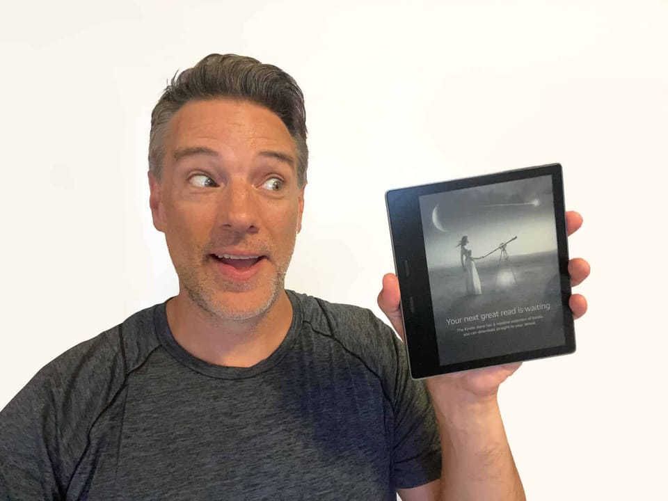 Me holding an Amazon Kindle Oasis.